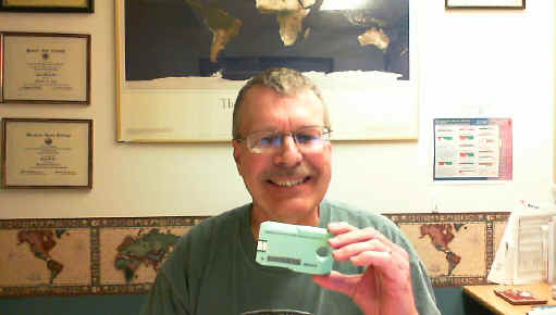 Smiling Pat holds up a single Library of Congress digital cartridge.  The small green cartridge is not quite as large as a single 4-track cassette tape.