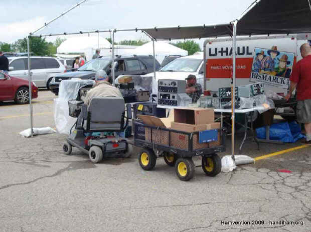 Guy driving scooter with wagon of Hamvention treasures in tow