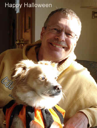 Pat, WA0TDA, holds Jasper the Corgi_Cocker Spaniel mix, who  is dressed up in his festive jester collar for Halloween.